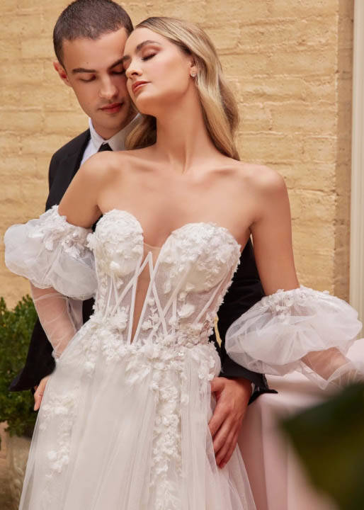 Сouple wearing a white gown and a black sui